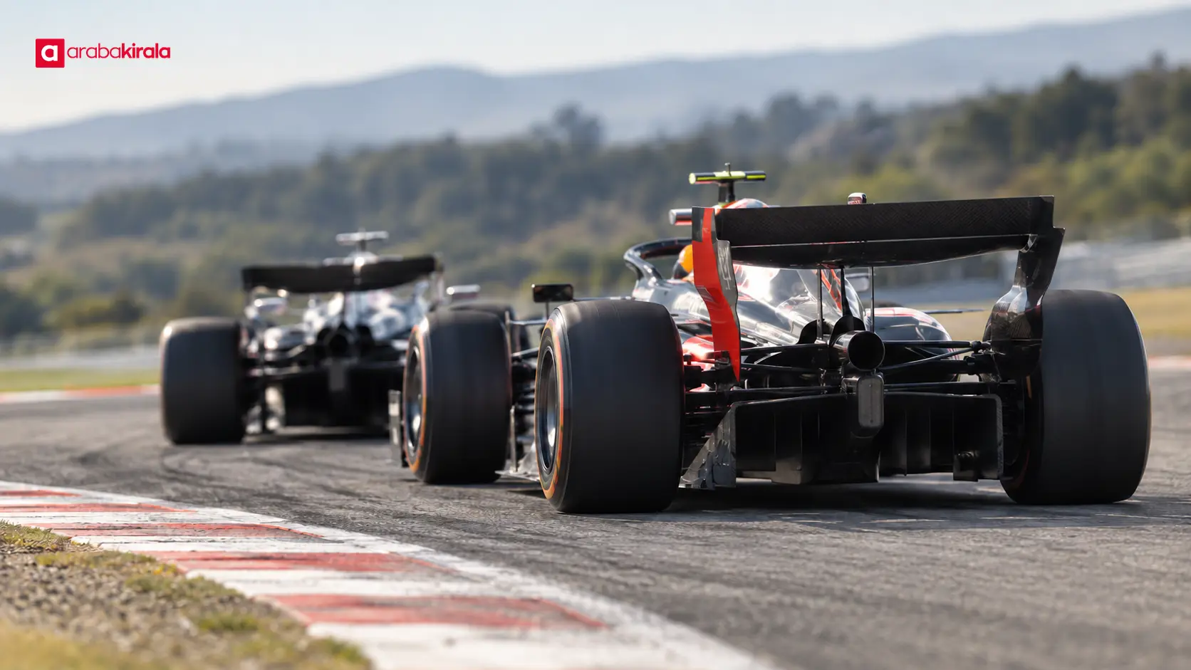 Difüzörü ve arka kanadı görülen Formula 1 aracı, arkadan takip eden başka bir otomobille Difüzörü ve arka kanadı görülen Formula 1 aracı, arkadan takip eden başka bir otomobille