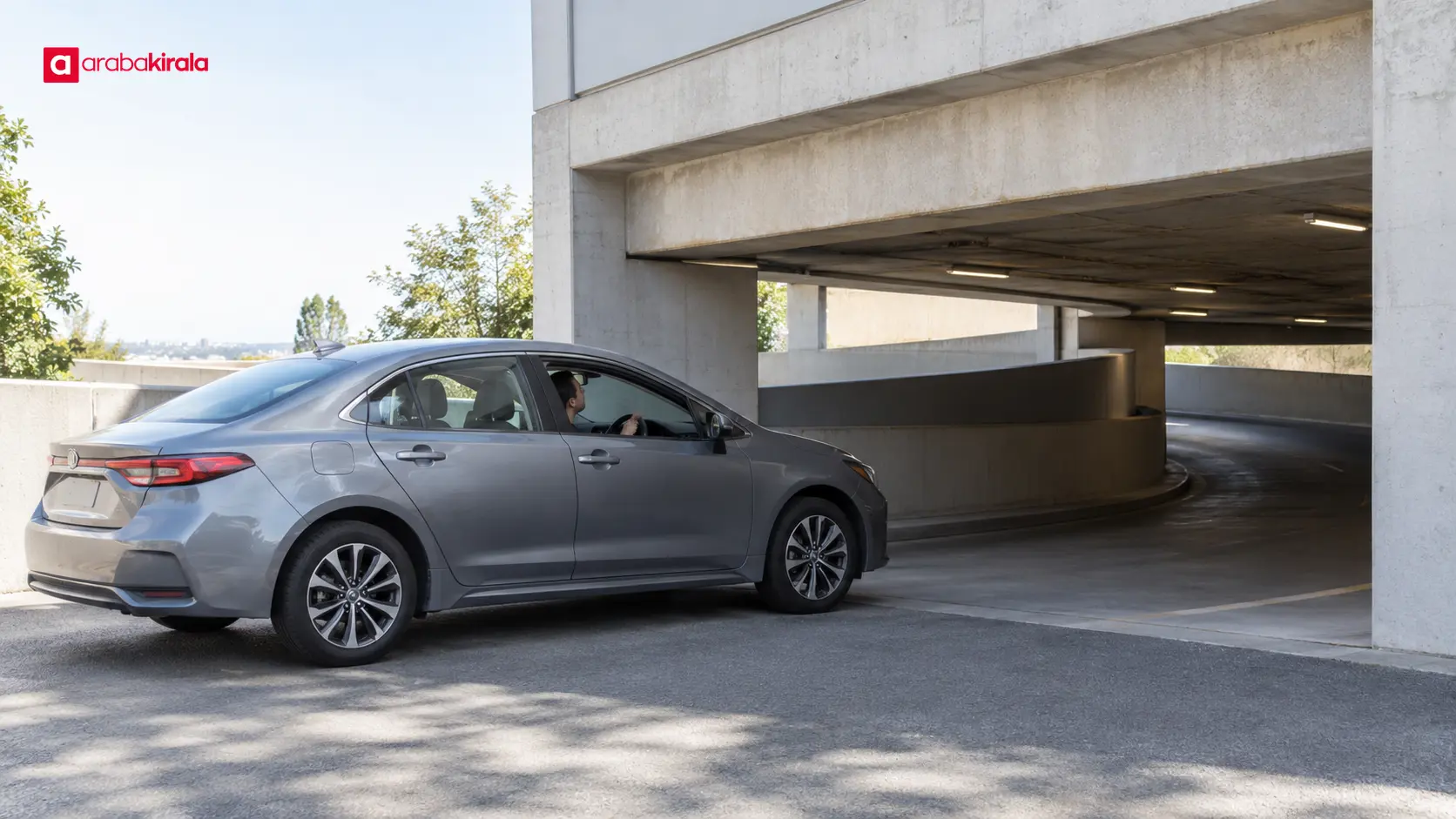 Kapalı otopark girişinde araç yüksekliğini ve manevra alanını kontrol eden sürücü Kapalı otopark girişinde araç yüksekliğini ve manevra alanını kontrol eden sürücü