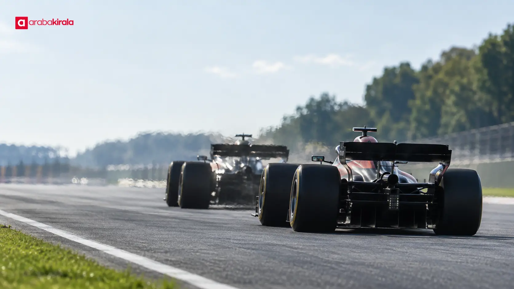 Uzun düzlükte öndeki Formula 1 aracını yakından takip eden yarış otomobili Uzun düzlükte öndeki Formula 1 aracını yakından takip eden yarış otomobili
