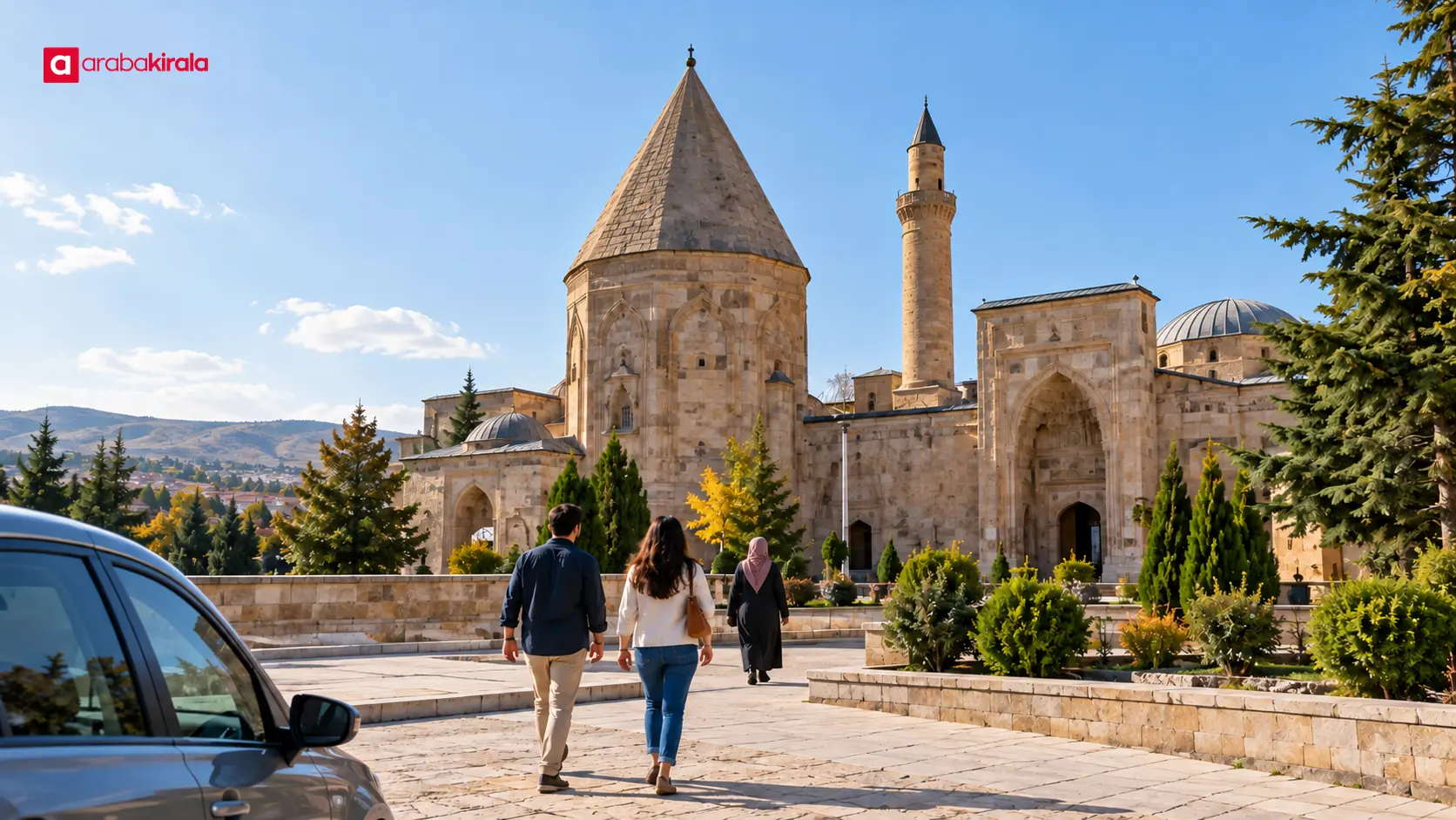 Kırşehir’de Ahi Evran Külliyesi’ne yürüyerek yaklaşan ziyaretçiler ve yakında park edilmiş bir otomobil Kırşehir’de Ahi Evran Külliyesi’ne yürüyerek yaklaşan ziyaretçiler ve yakında park edilmiş bir otomobil