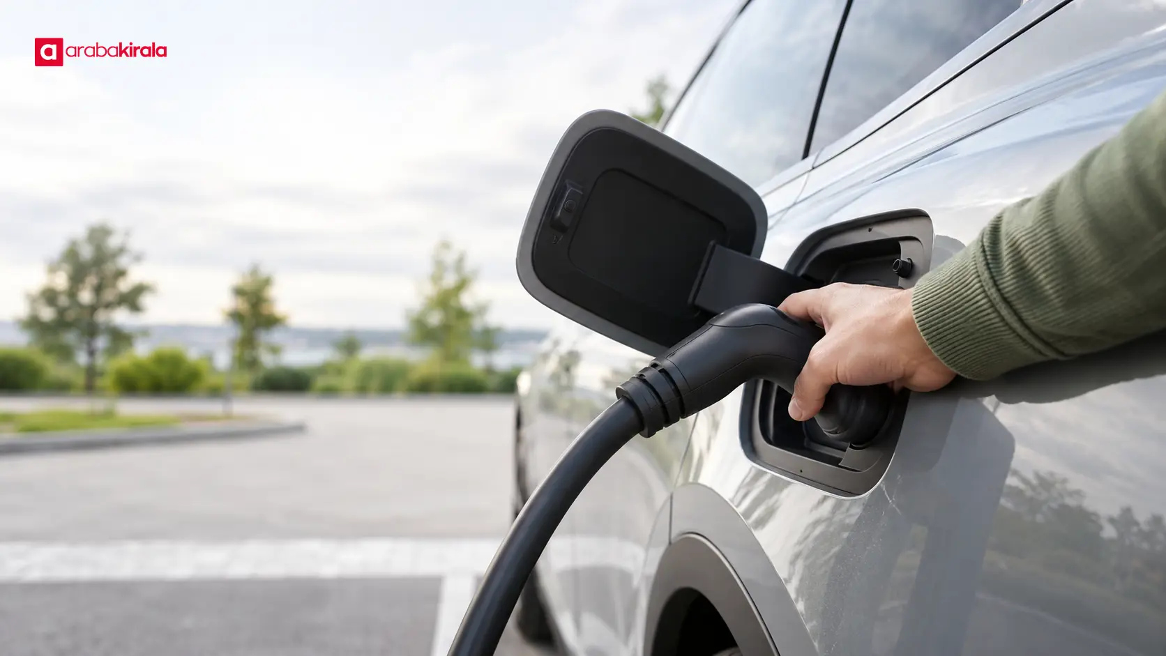 Sürücü, elektrikli otomobilini halka açık şarj istasyonuna bağlıyor Sürücü, elektrikli otomobilini halka açık şarj istasyonuna bağlıyor