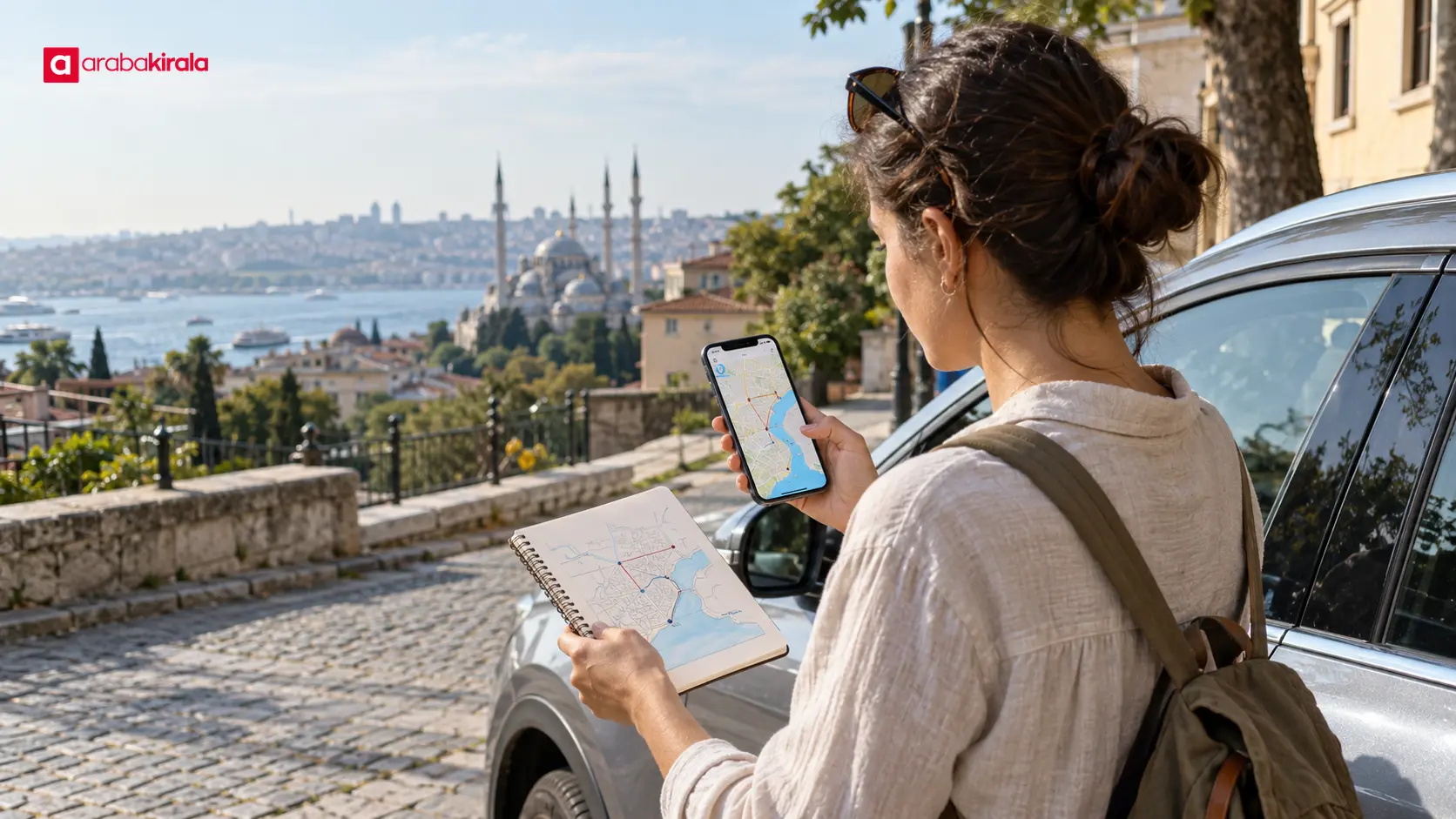 Park halindeki kiralık aracın yanında telefondan resmî haritayı inceleyen yolcu