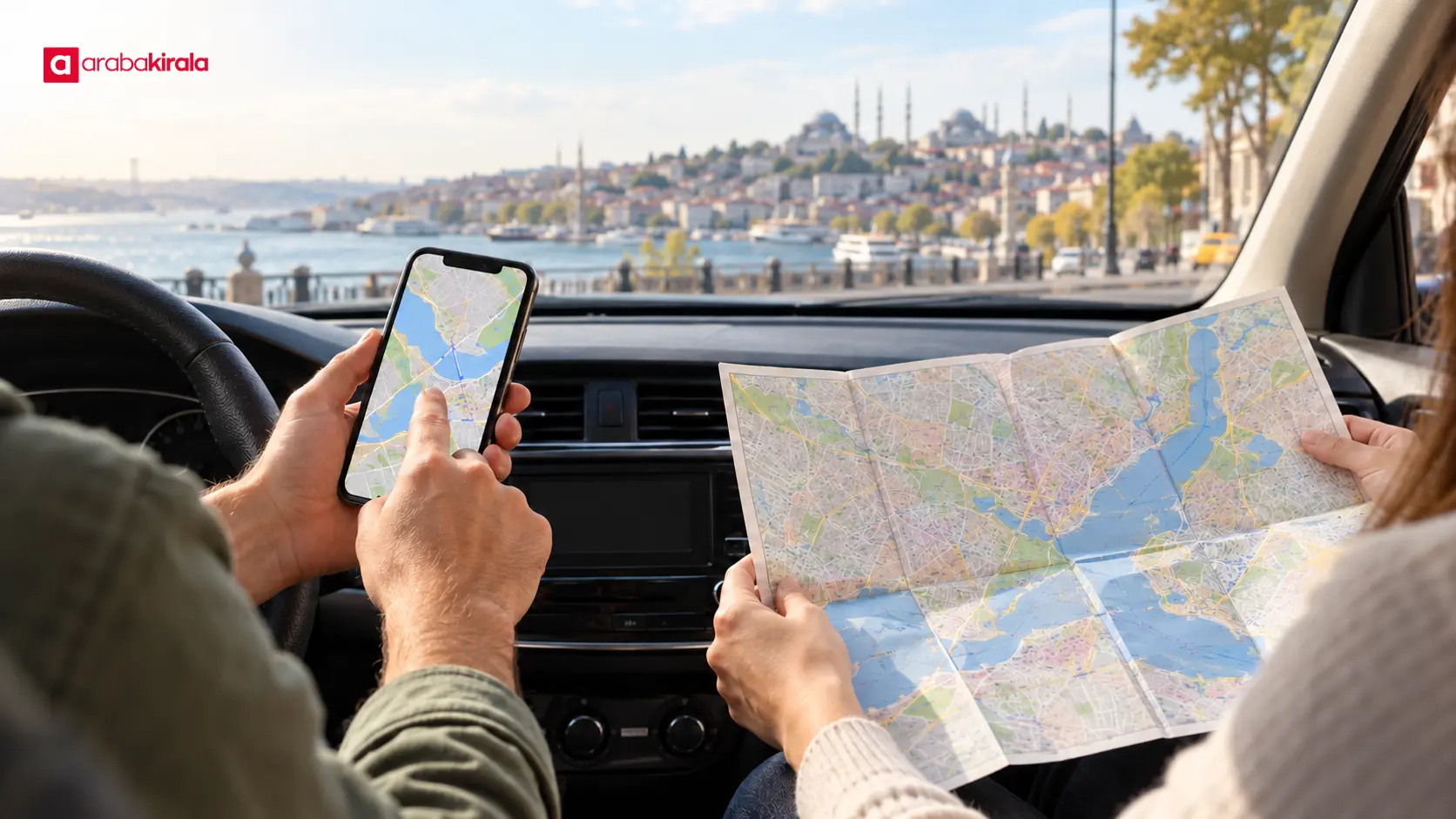 Duran araçta telefon haritası ve kâğıt şehir haritasıyla rota planlayan iki kişi